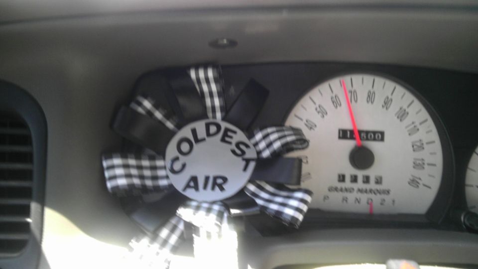 Dashboard with speedometer and 'Coldest Air' air freshener
