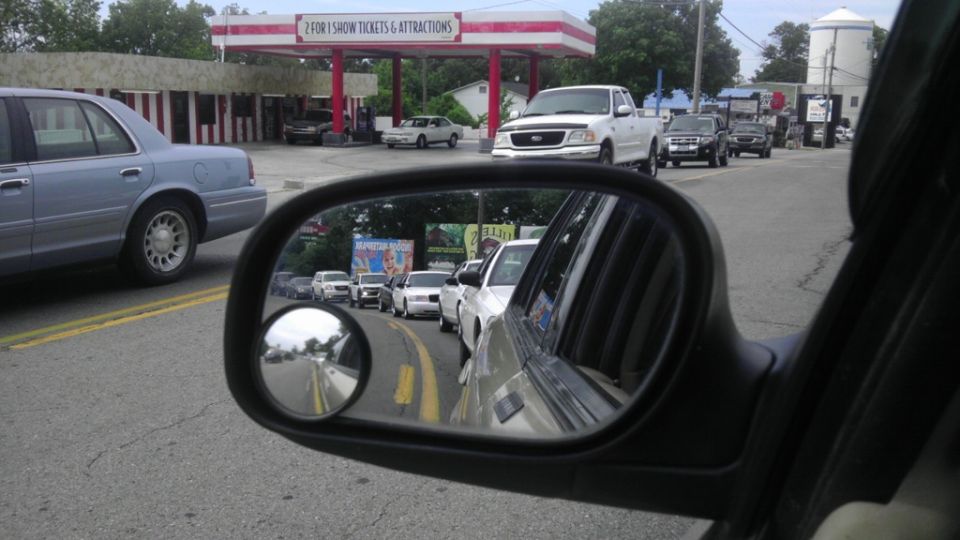 2000 Mercury Grand Marquis in traffic, side view. Gas station and other cars visible in side mirror