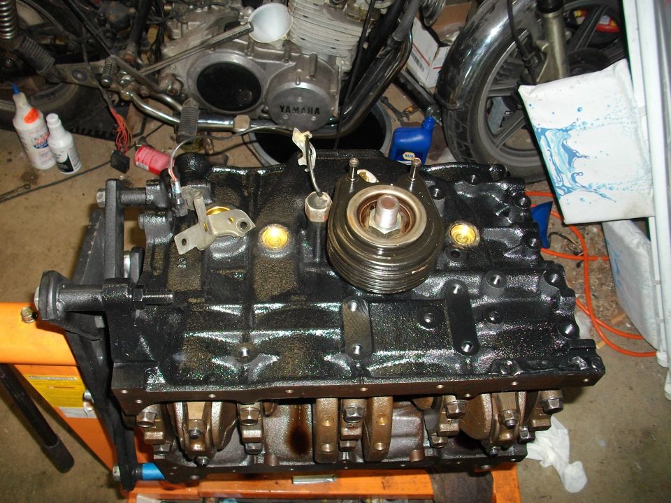 Black engine block on an orange stand, showing crankshaft and oil filter housing