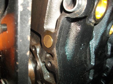 1989 Ford Probe - A brass plug is visible in the cast iron of an engine block, likely for oil or coolant passage.