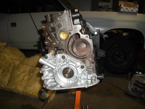 1989 Ford Probe - Engine block assembly with visible oil pump and mounting points, set against a backdrop of a car.
