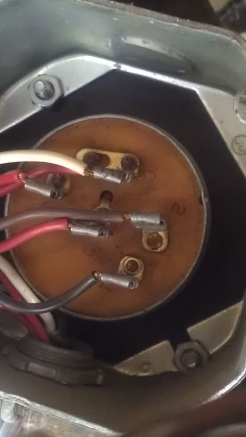 1991 Chevrolet Cheyenne - Close-up view of an electrical connector with multiple wires attached to a wooden disc, showing some visible text.