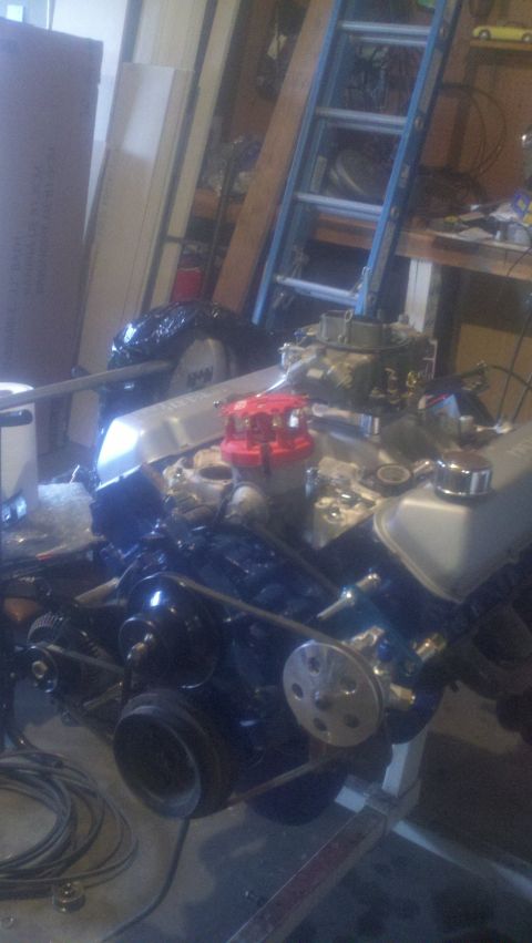 1967 Ford F-250 - Engine assembly on a stand in a workshop setting, showing the carburetor and distributor.
