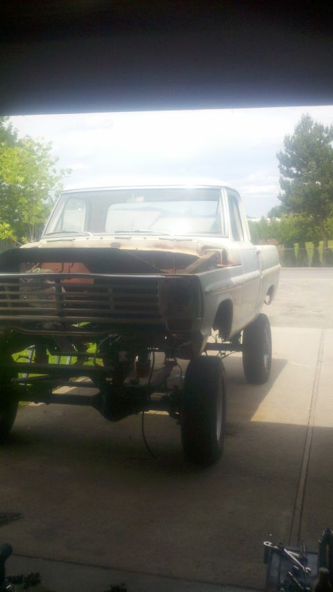 1967 Ford F-250 - This 1967 Ford F-250 pickup truck is lifted and undergoing repairs, with its front grille and hood removed.