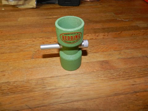 1996 Ford Bronco - A Redding powder funnel sits on a wooden table. The funnel is green with a red and orange label.