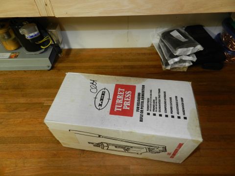 1996 Ford Bronco - A box for a reloading press sits on a wooden surface under cabinets.