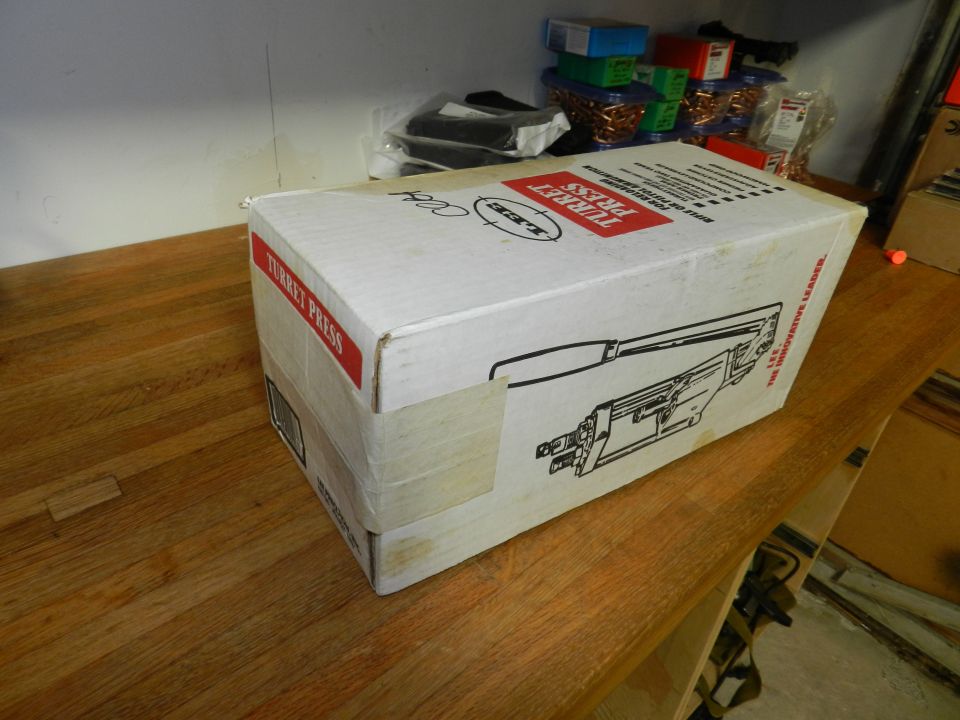 Cardboard box with red label "TURRET PRESS" and diagram of a press on a wooden surface
