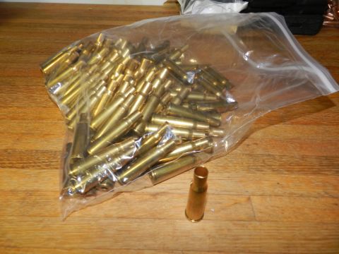 1996 Ford Bronco - Bag of spent shell casings on a wooden surface.