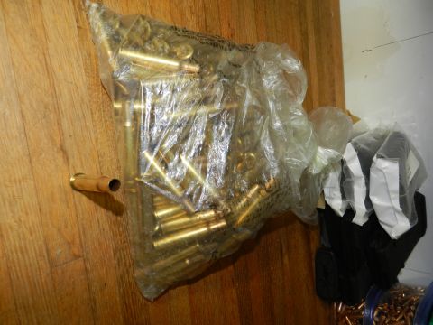 1996 Ford Bronco - A plastic bag filled with brass casings sits on a wooden floor next to other bagged items.