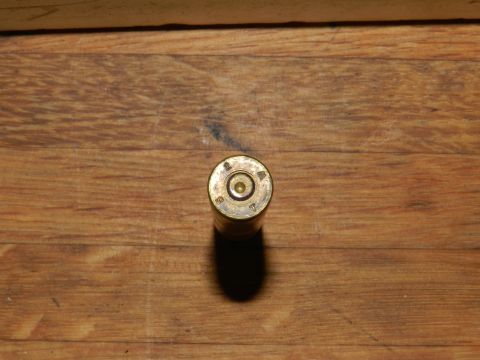 1996 Ford Bronco - A single ammunition casing is shown on a wooden surface, with visible markings.