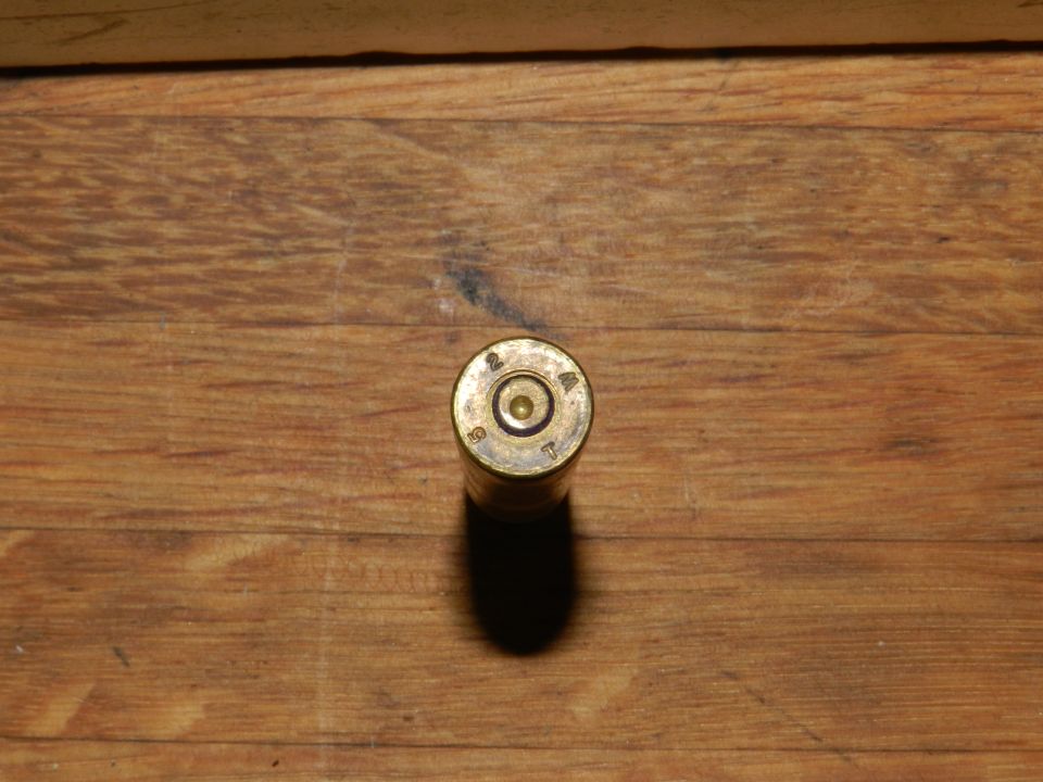 Ammunition casing with markings '2 94 T' on a wooden surface
