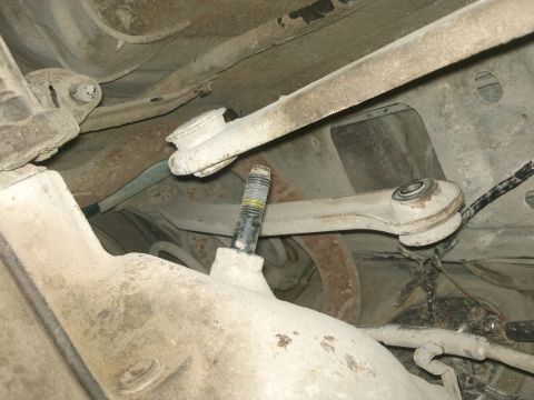 1998 Ford Crown Victoria - Close-up view of the rear suspension system, showing various linkages and a central bolt.