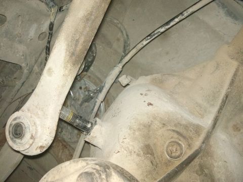 1998 Ford Crown Victoria - Underside view of rear axle and suspension components, covered in dust.