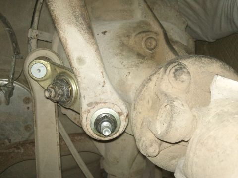 1998 Ford Crown Victoria - Undercarriage view of a vehicle's rear suspension system, focusing on the watts link mechanism.