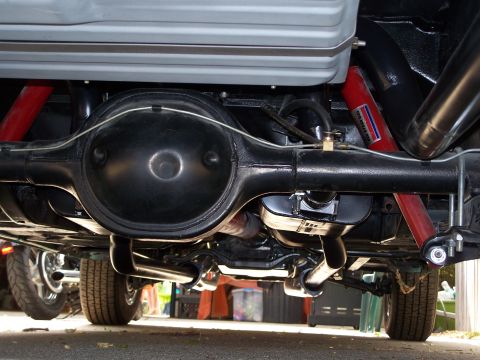 1971 Ford Ranchero - Close-up of a vehicle's rear axle and suspension components, including red shocks and exhaust system.