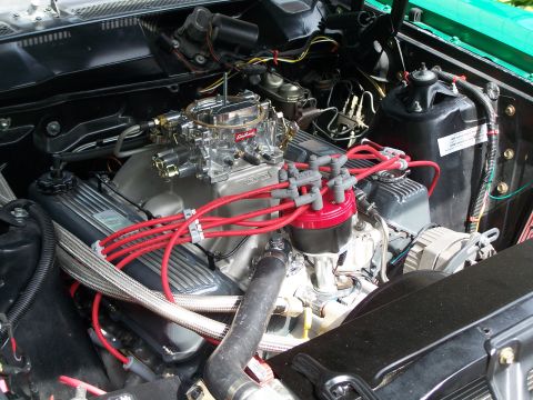 1971 Ford Ranchero - Close-up view of a V8 engine bay an Edelbrock carburetor and bright red spark plug wires.