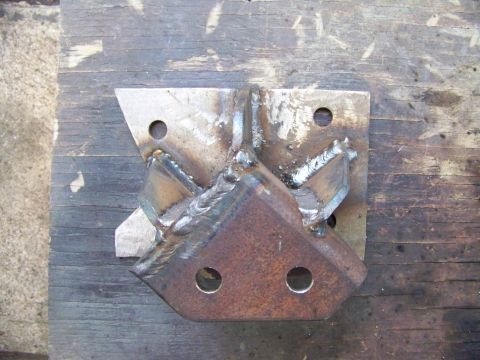 1985 Ford Bronco - Custom welded metal bracket, likely for automotive modification, shown on a wooden workbench.