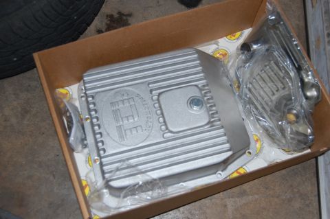 1985 Mercury Grand Marquis - A new transmission pan and associated parts are shown inside a cardboard box, ready for installation.
