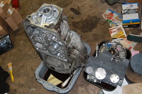 1985 Mercury Grand Marquis - Transmission components are laid out for inspection and repair on a workshop floor.