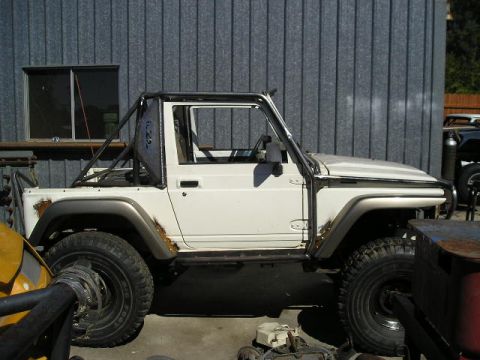 1987 Suzuki Samurai - Modified 1987 Suzuki Samurai shows custom roll cage and off-road tires.