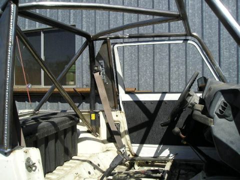 1987 Suzuki Samurai - The interior of a Suzuki Samurai is shown, a custom roll cage and basic seating.