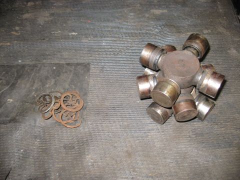 1994 Ford Bronco - A universal joint and a pile of bearing clips are shown, likely parts for a vehicle's driveshaft.