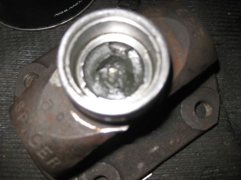 1994 Ford Bronco - Close-up of a driveshaft component, possibly a U-joint yoke, showing wear and the 'Spicer' manufacturer marking.