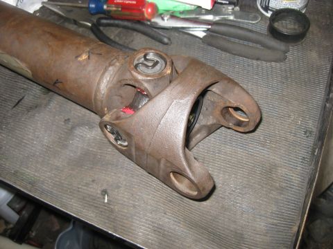 1994 Ford Bronco - Close-up view of a driveshaft U-joint, showing signs of wear and red grease.