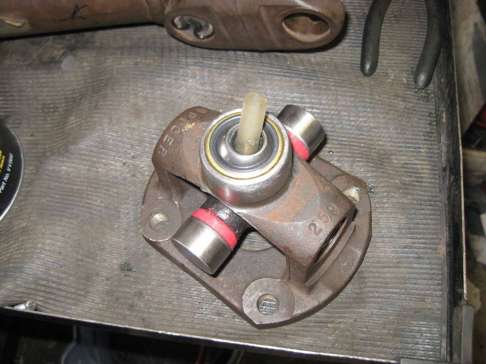 Driveshaft universal joint with Spicer markings and a bearing. Part of a driveshaft rebuild