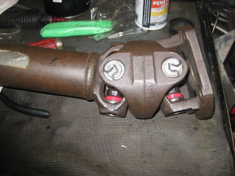 1994 Ford Bronco - Close-up view of a driveshaft's universal joint, showing new red seals installed.