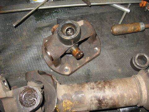 1994 Ford Bronco - Close-up of a worn driveshaft universal joint and a section of the driveshaft, with tools nearby.