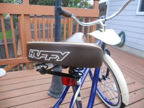 1953 Ford Mainline - A close-up view of a blue bicycle, highlighting its brown seat with the 'HUFFY' logo and chrome handlebars.