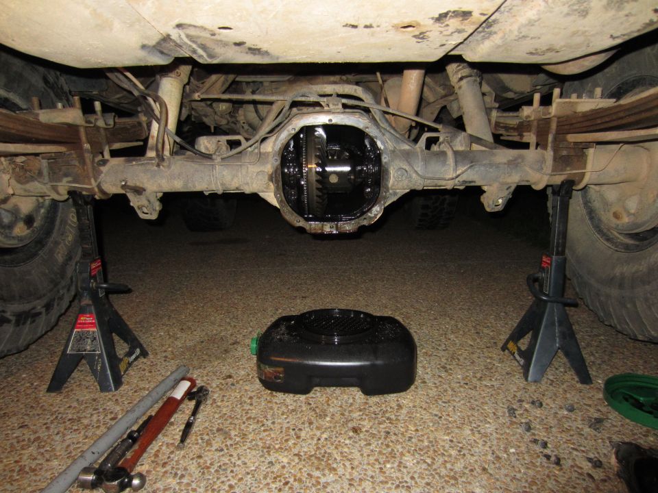 Rear differential removed from vehicle on jack stands, with oil drain pan below