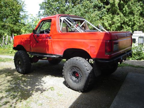 1989 Ford Bronco - This lifted 1989 Ford Bronco features a prominent roll cage and large off-road tires.