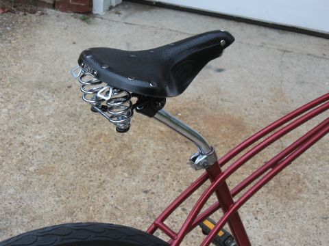 1994 Ford Bronco - A close-up view of a bicycle seat with chrome springs attached to its red frame.