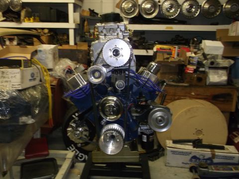 1971 Ford Ranchero - Custom V8 engine assembly on a stand, with various parts and shelves in the background.