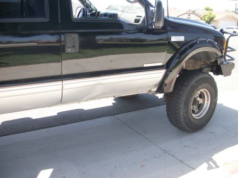 2001 Ford F-250 - This 2001 Ford F-250 pickup truck is shown from the side, a two-tone paint scheme and aftermarket fender flares.