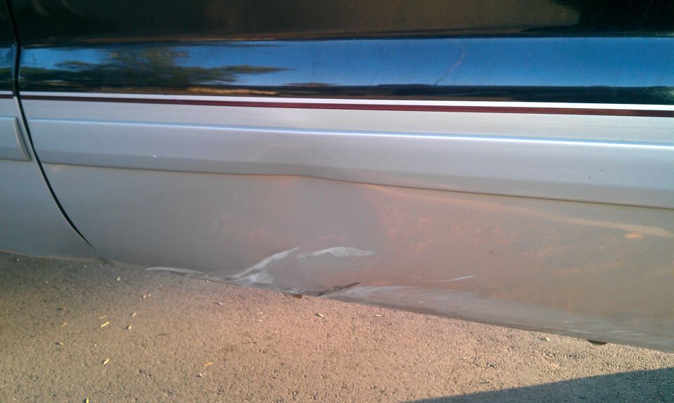 Damaged lower body panel on a two-tone vehicle