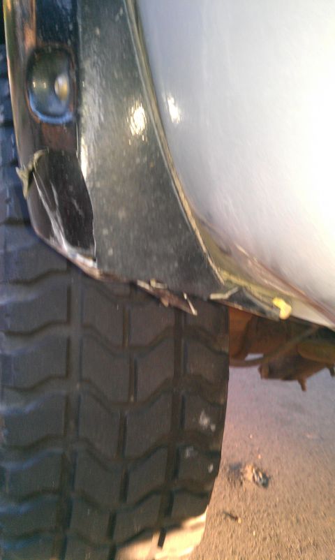 2001 Ford F-250 - The vehicle's fender shows significant damage near the tire.