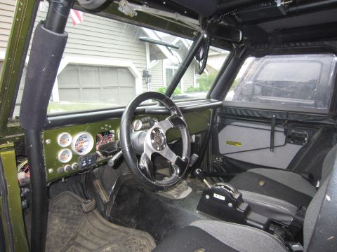 1974 Ford Bronco - Custom interior of an off-road vehicle with aftermarket gauges and racing seats.