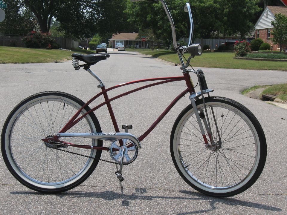 Maroon cruiser bicycle with whitewall tires and chrome handlebars