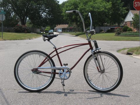 1994 Ford Bronco - Cruiser bicycle with wide handlebars and whitewall tires sits on a suburban street.