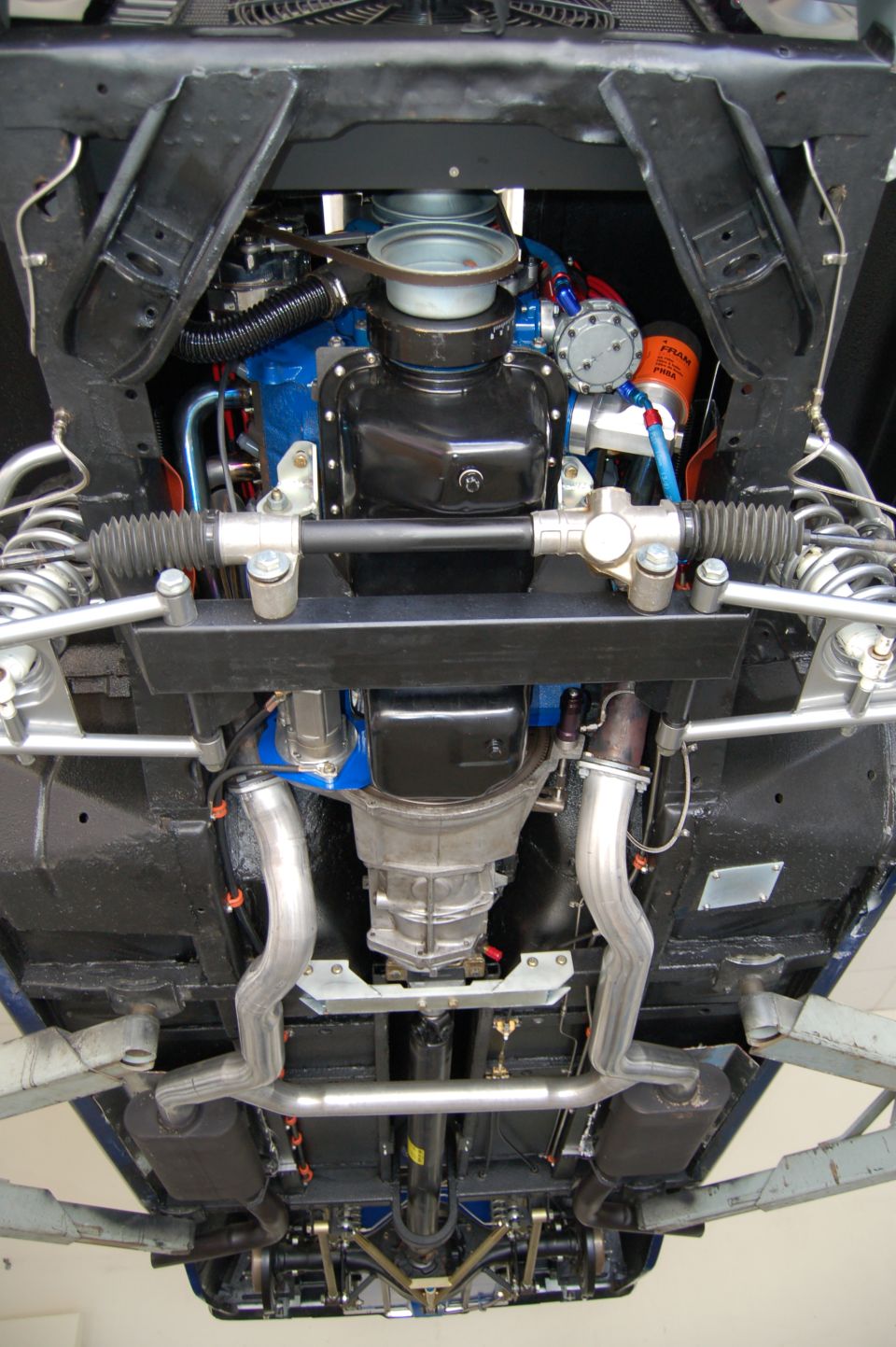 Underside view of a car's engine, transmission, exhaust system, and suspension components
