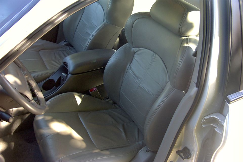 Gray leather bucket seats and center console seen through an open driver's door