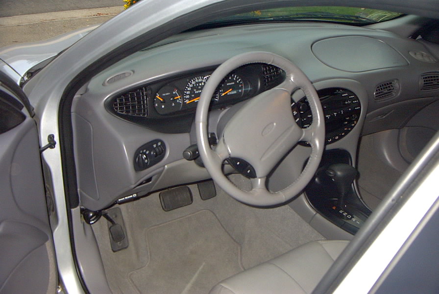 Gray car interior dashboard, steering wheel, gauge cluster and center console