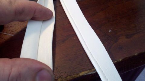 1900 Ford C-350 (Centurion Conversions) - Close-up of white fabric trim showing stitching detail, likely an interior part.