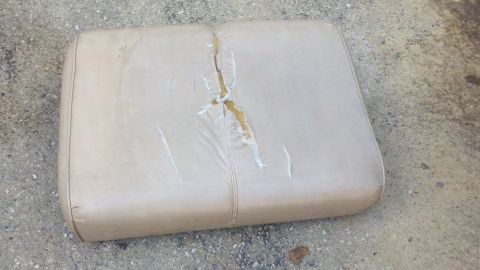 1900 Ford C-350 (Centurion Conversions) - Damaged car seat cushion shown resting on a concrete surface.
