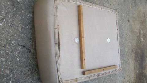 1900 Ford C-350 (Centurion Conversions) - A beige upholstered panel with wooden supports is shown from the underside, with a tear in the fabric.