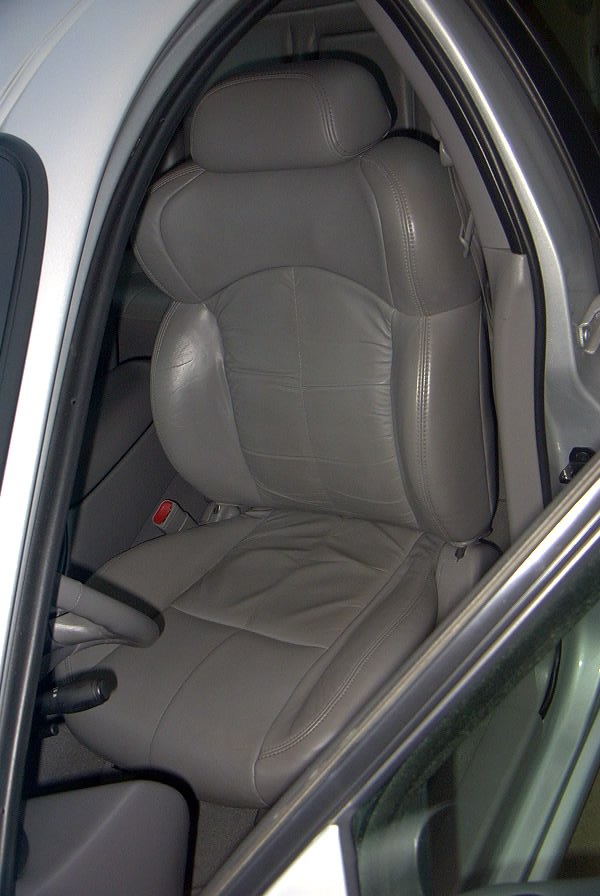Gray leather front driver's seat of a car viewed through the open door