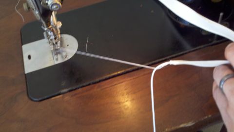 1900 Ford C-350 (Centurion Conversions) - Sewing machine needle is piercing clear tubing with white thread.